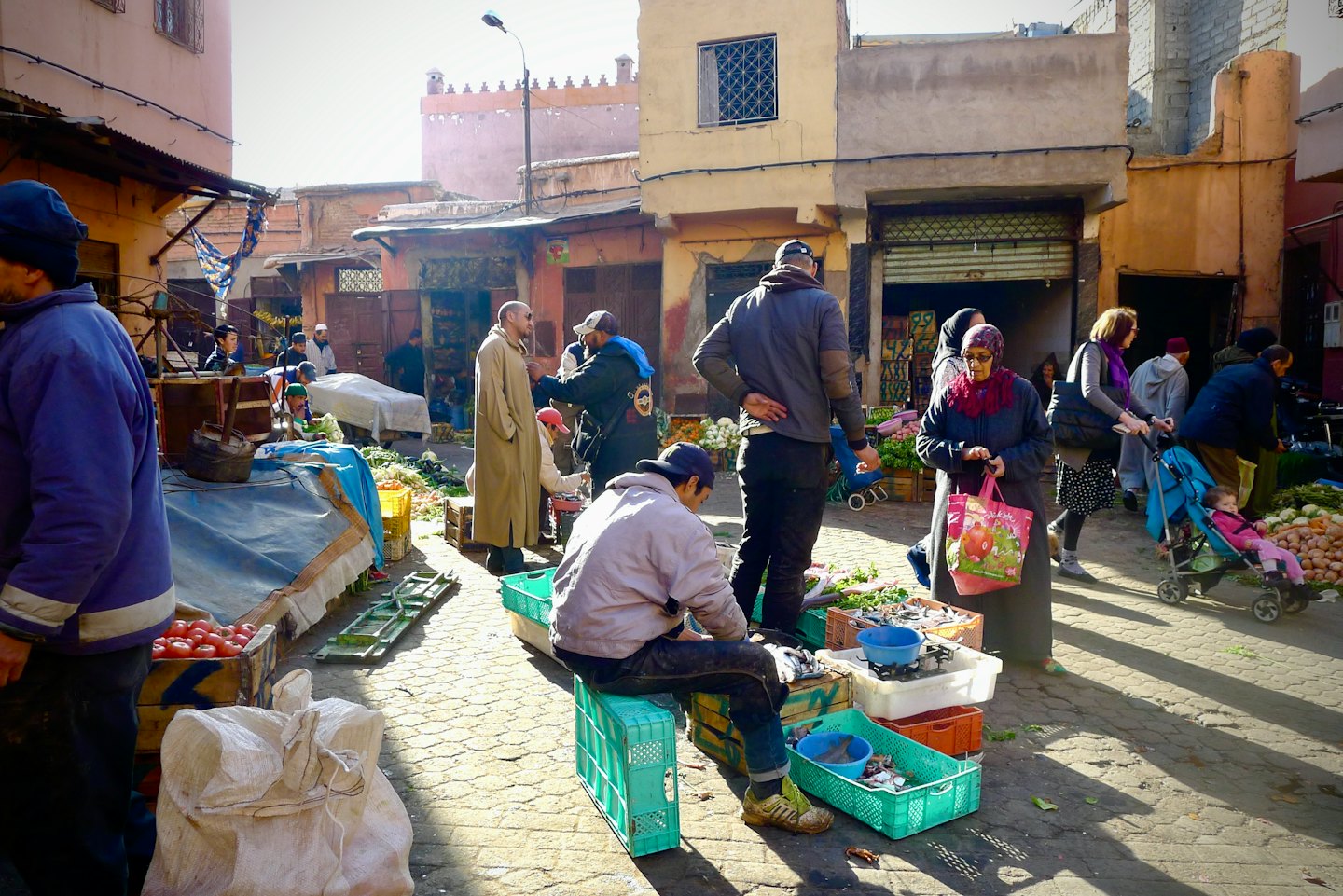 Winkelen op een drukke markt met verse producten op een straat met kasseien.